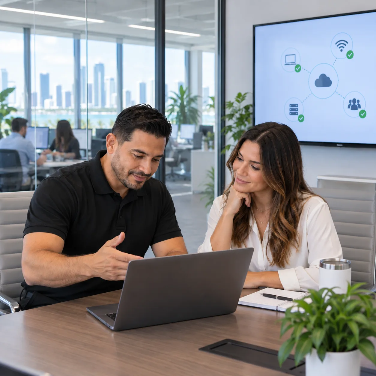 Technician assisting a client with her laptop in a Miami office