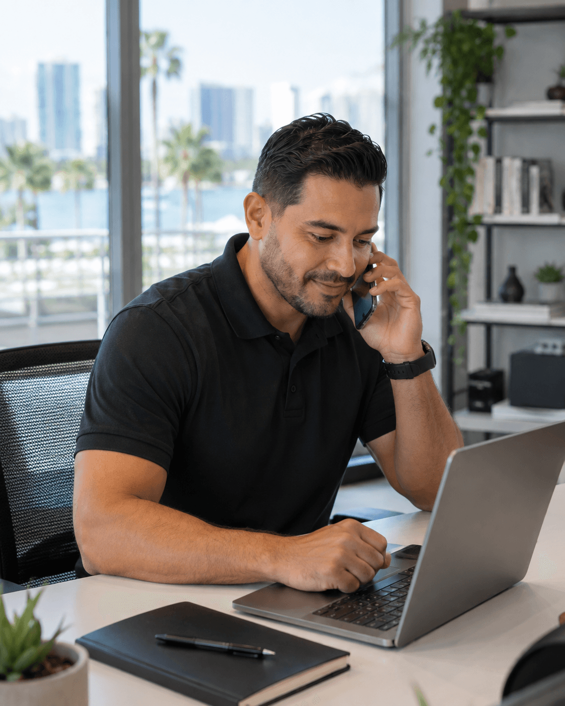 Technician coordinating a business support visit by phone while checking his laptop